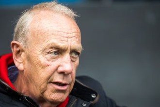 Close-up of Lyndon Faulkner, in a red scarf and dark quilted jacket, looking to his left at Cardiff Arms Park
