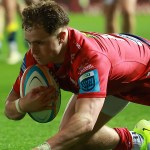 Scarlets wing Macs Page diving to score a try in a URC match