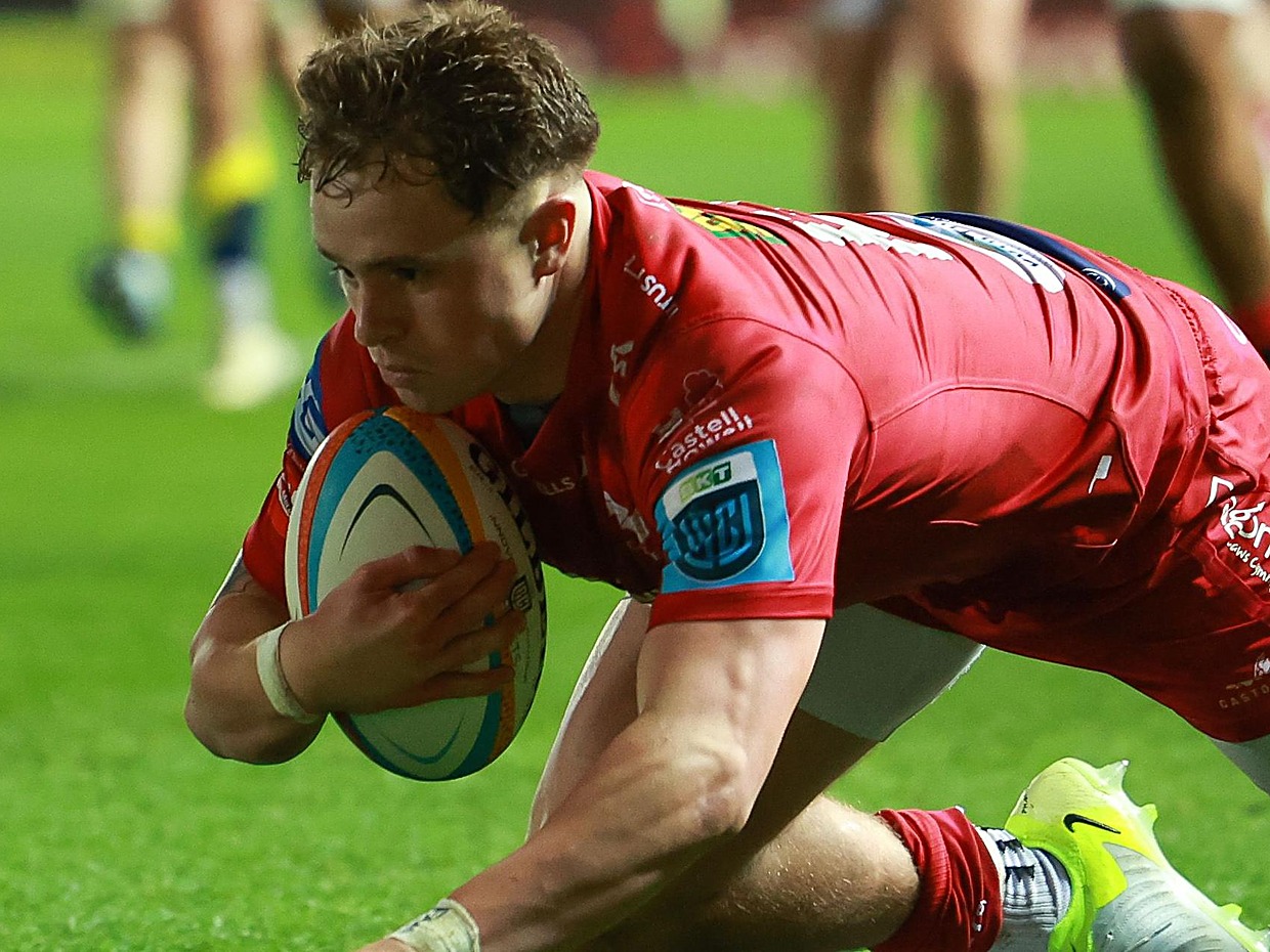 Scarlets wing Macs Page diving to score a try in a URC match