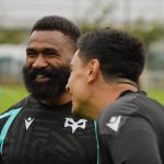 Ospreys wing Marika Koroibete, bearded and smiling, in a black Ospreys training top as a team-mate laughs beside him