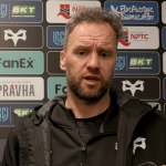 Ospreys head coach Mark Jones speaking to the media in front of a sponsor board after the win over the Dragons.