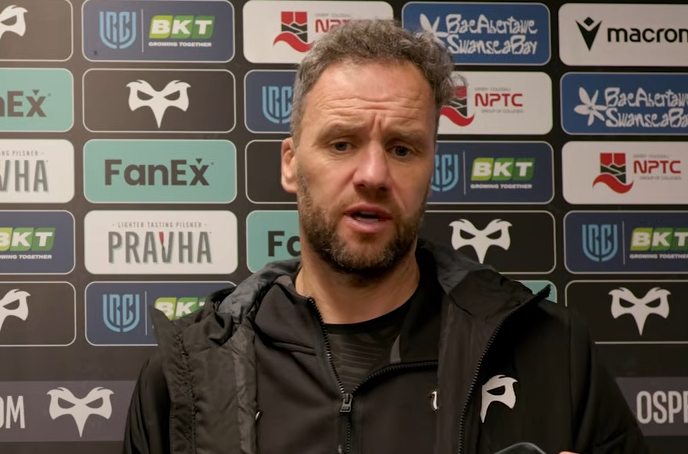 Ospreys head coach Mark Jones speaking to the media in front of a sponsor board after the win over the Dragons.