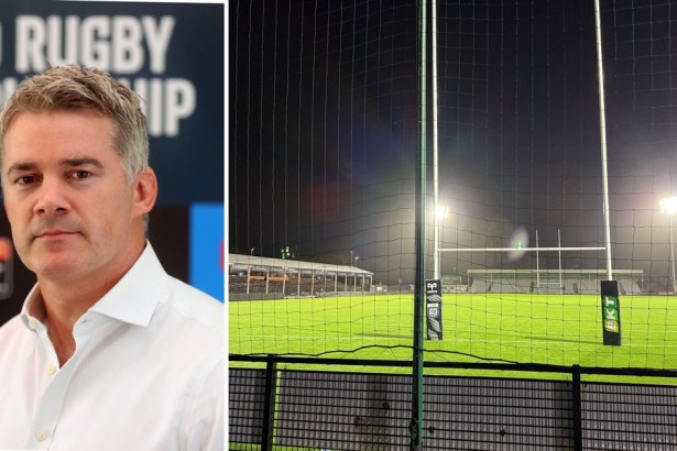 Martin Anayi in a white shirt in front of a United Rugby Championship backdrop, beside the floodlit pitch and posts at St Helen's at night