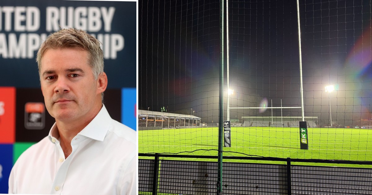 Martin Anayi in a white shirt in front of a United Rugby Championship backdrop, beside the floodlit pitch and posts at St Helen's at night