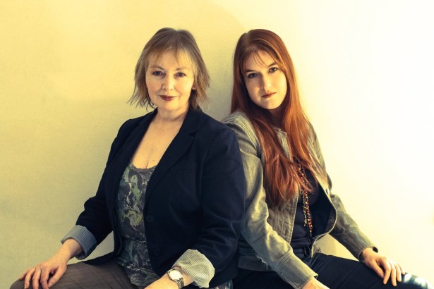 Mary Hopkin and her daughter Jessica Lee Morgan sitting back to back against a plain wall