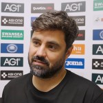 Swansea City head coach Vitor Matos speaks to the media in front of a sponsor board