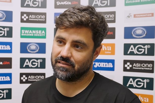 Swansea City head coach Vitor Matos speaks to the media in front of a sponsor board