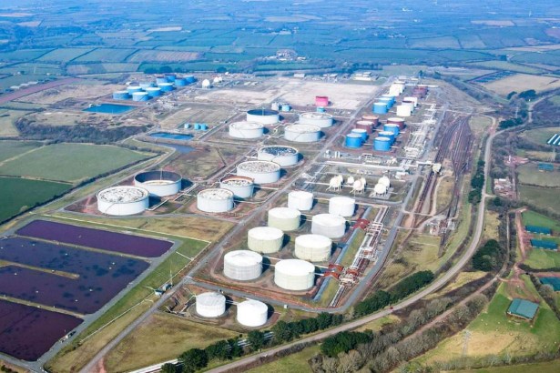 Aerial view of the Impala fuel terminal at Milford Haven, with rows of white and blue storage tanks, rail sidings and lagoons surrounded by Pembrokeshire farmland