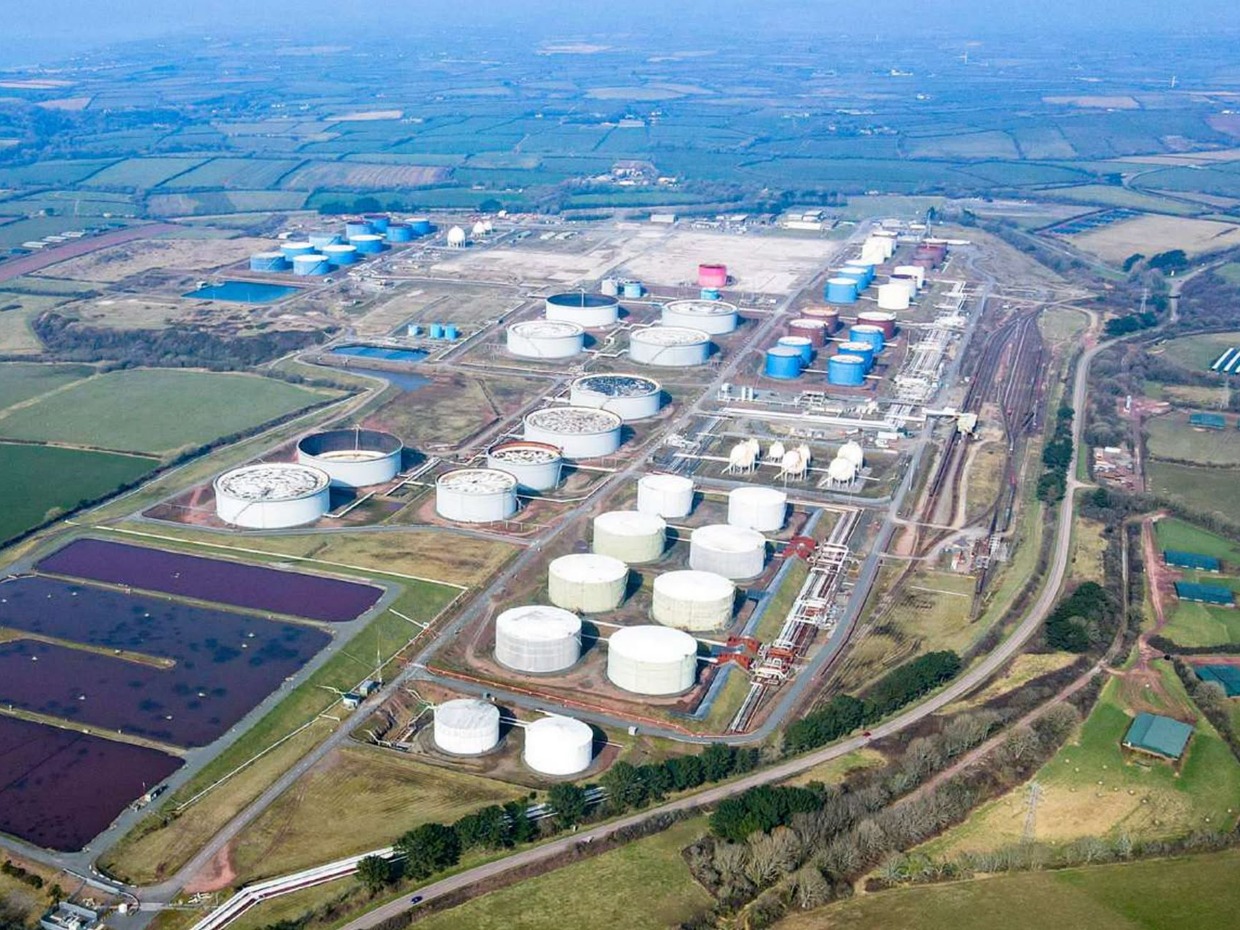 Aerial view of the Impala fuel terminal at Milford Haven, with rows of white and blue storage tanks, rail sidings and lagoons surrounded by Pembrokeshire farmland
