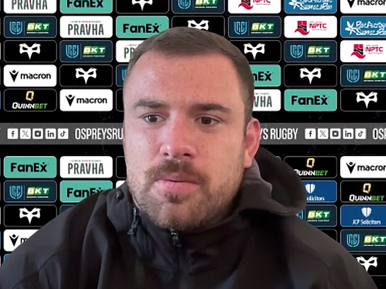 Ospreys number eight Morgan Morris at a press conference in front of a sponsor board