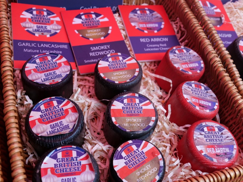Baskets of small black and red waxed cheeses labelled Garlic Lancashire, Smokey Redwood and Red Arrow from The Great British Cheese Company