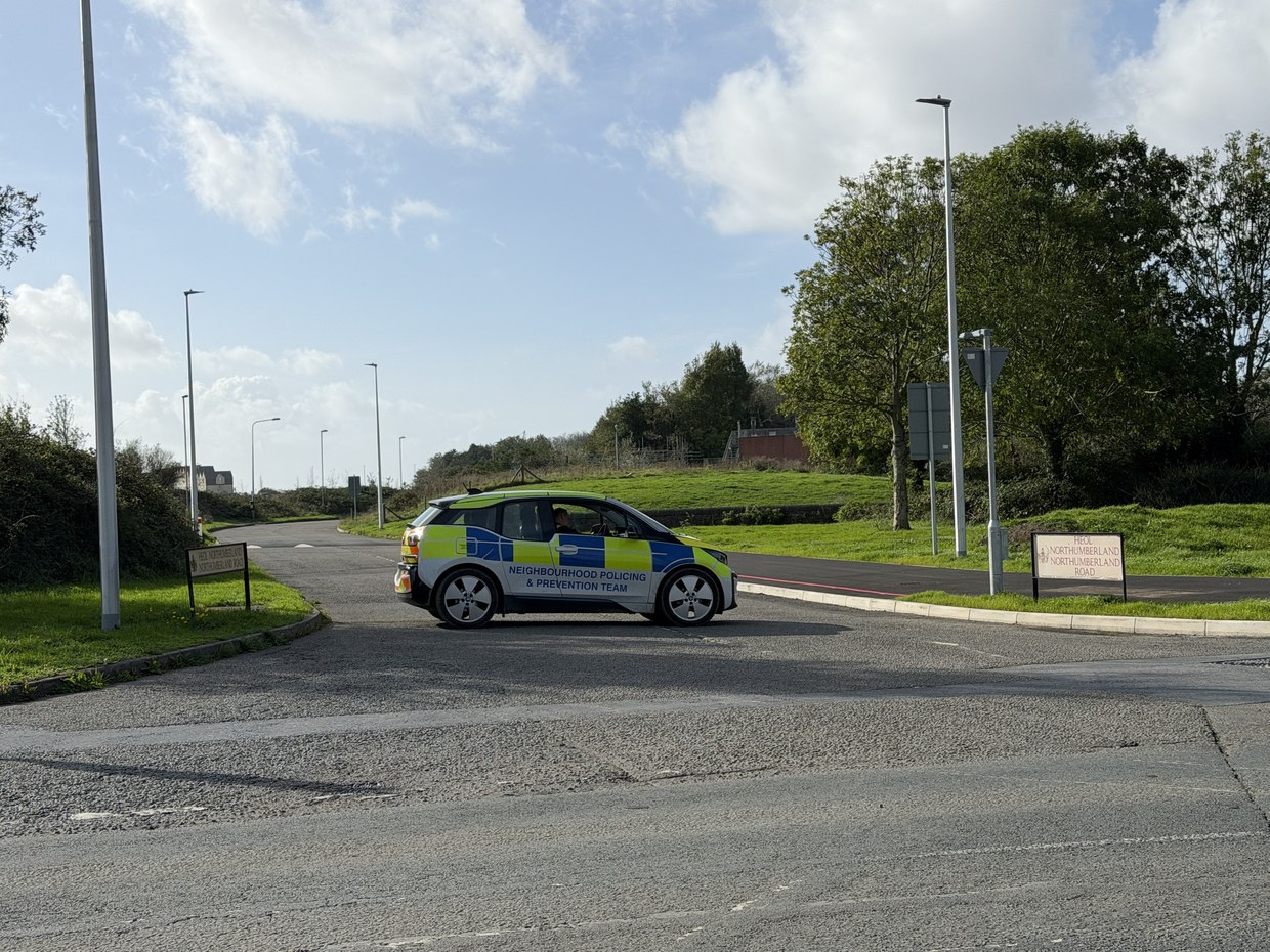A Dyfed-Powys Police neighbourhood policing car parked across the entrance to Northumberland Road in Llanelli, with the road signs either side