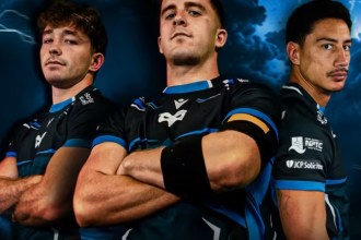 Three Ospreys players with arms folded in the dark blue and silver 2026/27 European kit against a stormy sky