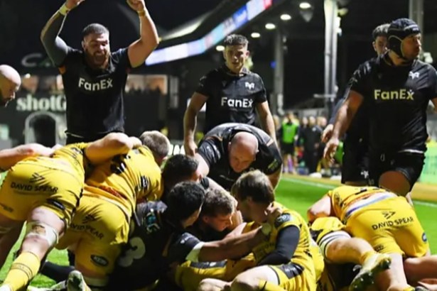 Ospreys players celebrate as a maul goes over the Dragons' line at Rodney Parade