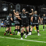 Ospreys number eight Morgan Morris punches the air as team-mates celebrate a try at the rebuilt St Helen’s, with the new stand behind.