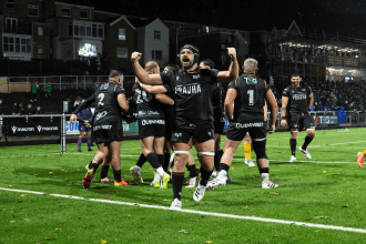 Ospreys number eight Morgan Morris punches the air as team-mates celebrate a try at the rebuilt St Helen’s, with the new stand behind.