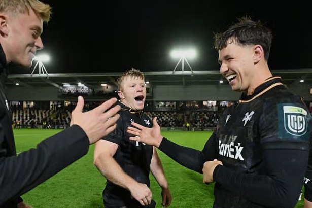 Ospreys players Iestyn Hopkins and Tom Rogers smile and celebrate on the pitch at Rodney Parade after the win over the Dragons