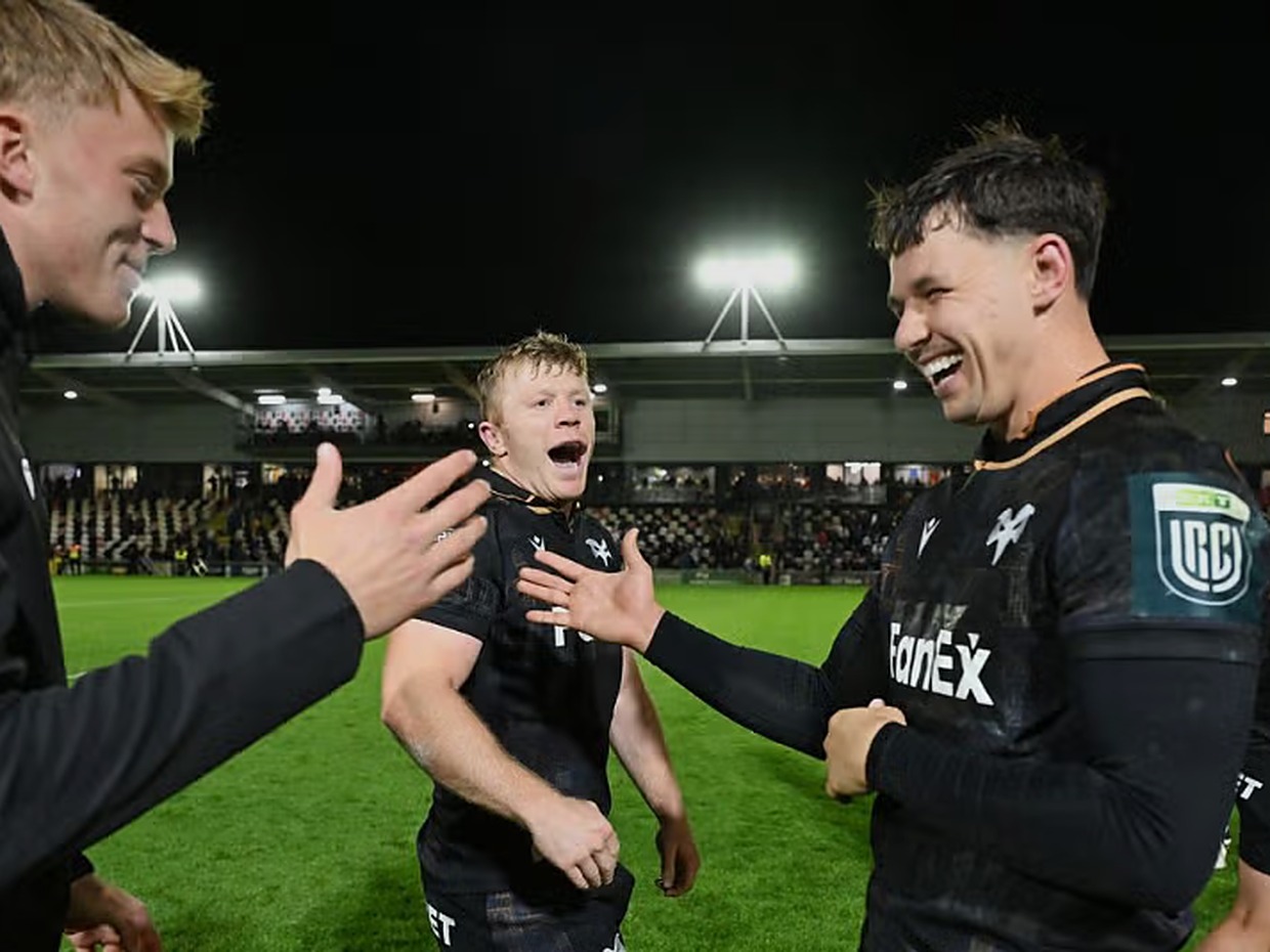 Ospreys players Iestyn Hopkins and Tom Rogers smile and celebrate on the pitch at Rodney Parade after the win over the Dragons