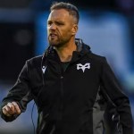 Ospreys head coach Mark Jones on the pitch in a black Ospreys jacket