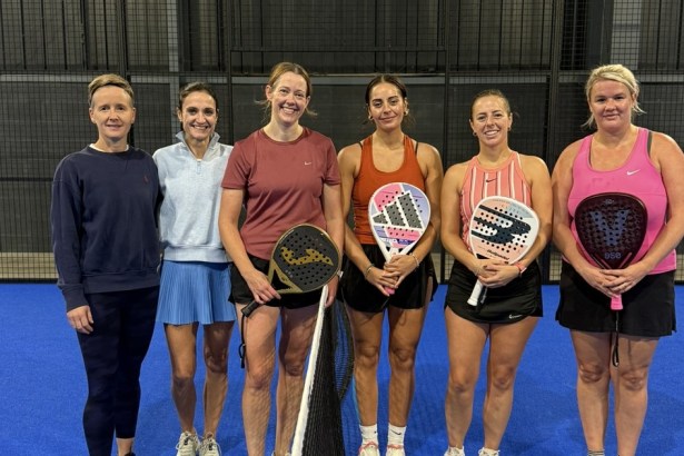 Six women players line up at the net on a blue court at Jaxx Padel in Llansamlet during the UK Padel Masters Series