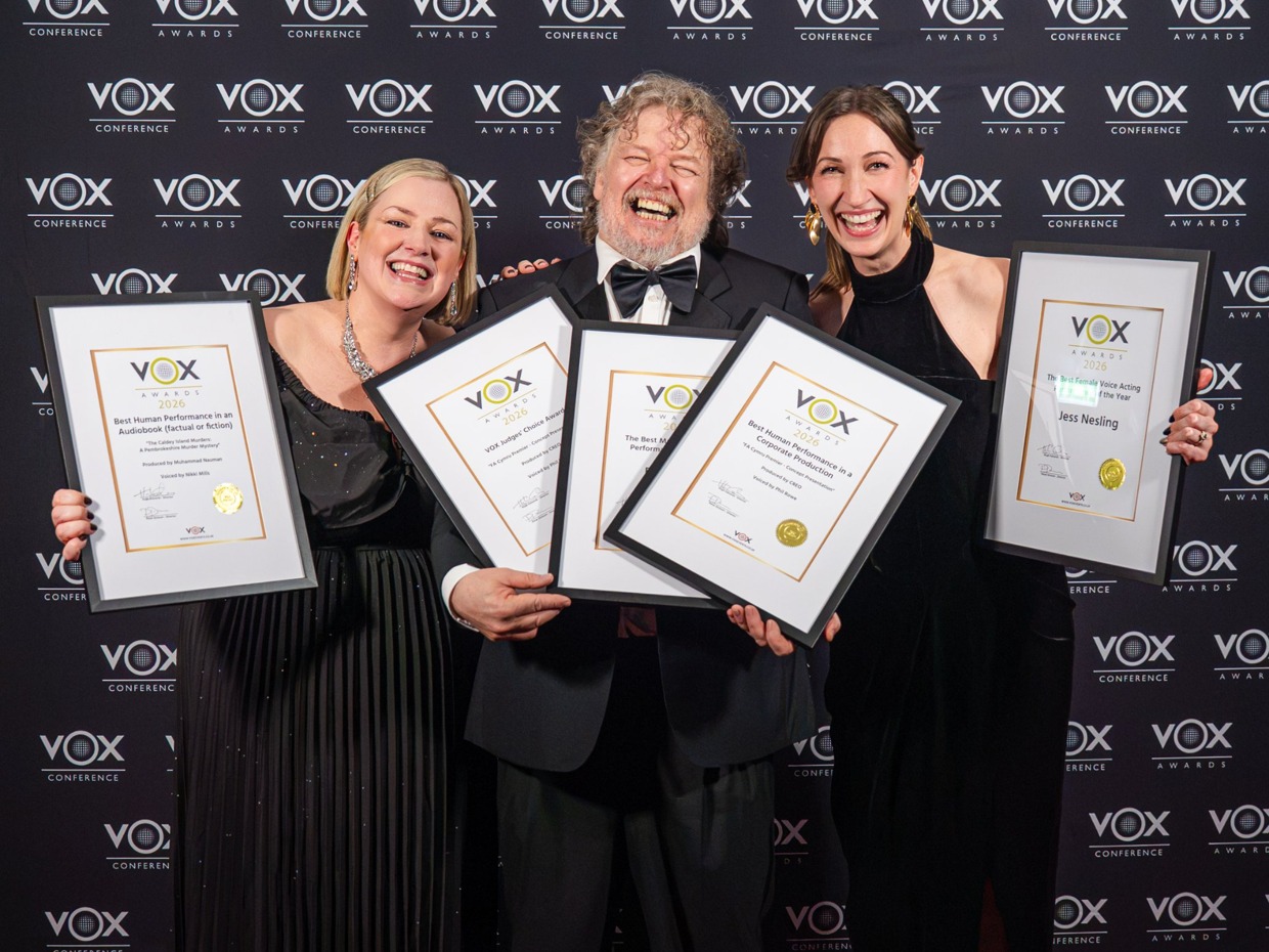 Nikki Mills, Phil Rowe and Jess Nesling laugh on the red carpet holding five framed VOX Awards certificates