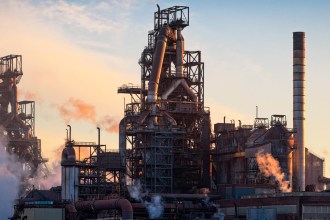 The blast furnaces and stoves at Tata's Port Talbot steelworks at sunset, with steam rising from the pipework