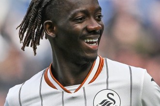 Swansea City winger Moussa Yeo smiling in the white Swans home kit