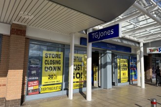 Yellow store closing down posters in the windows of the TGJones shop at Parc Trostre retail park in Llanelli