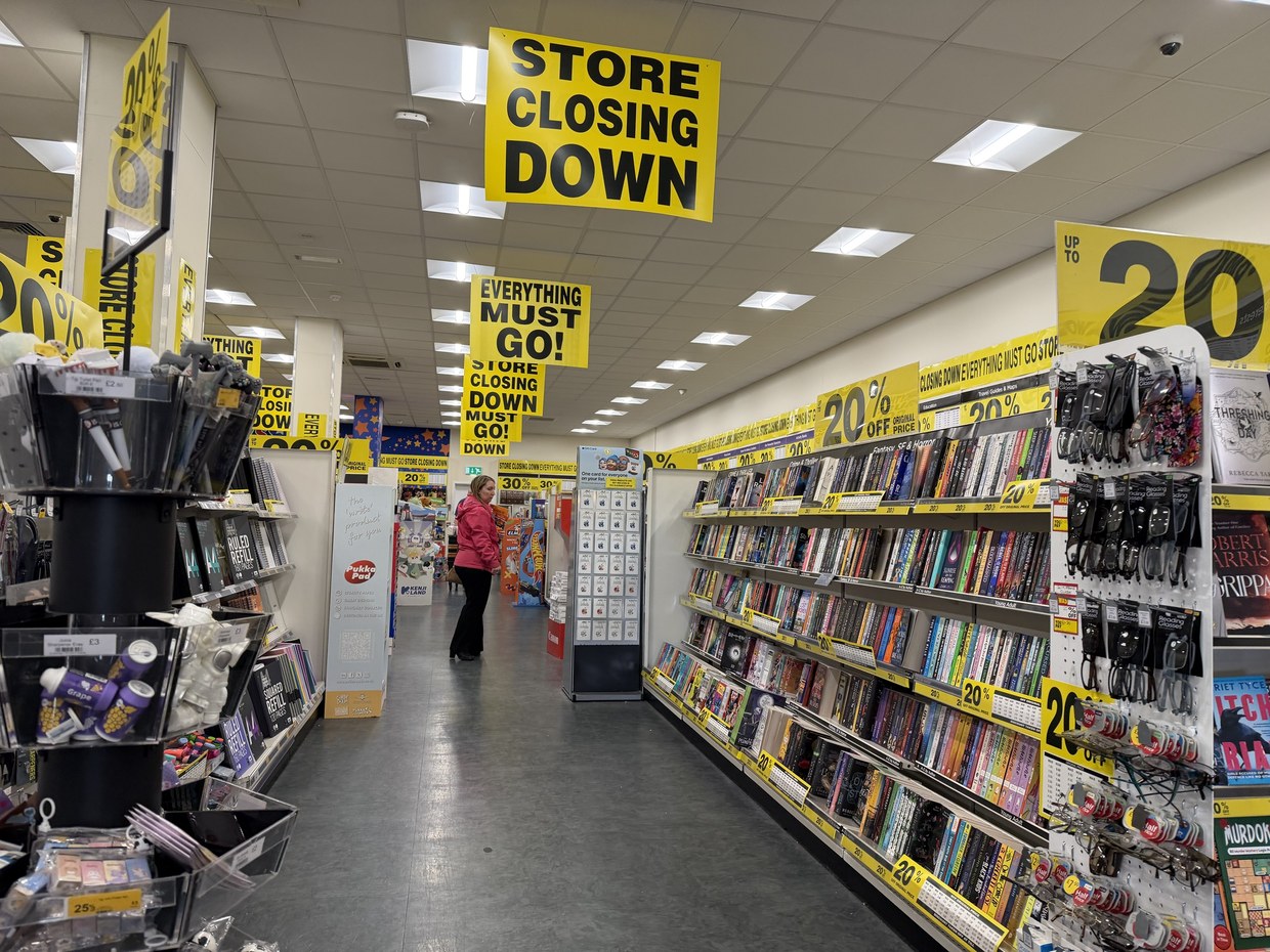 Shelves of books and stationery inside the TGJones store at Parc Trostre, Llanelli, with 20% and 30% off closing-down sale stickers