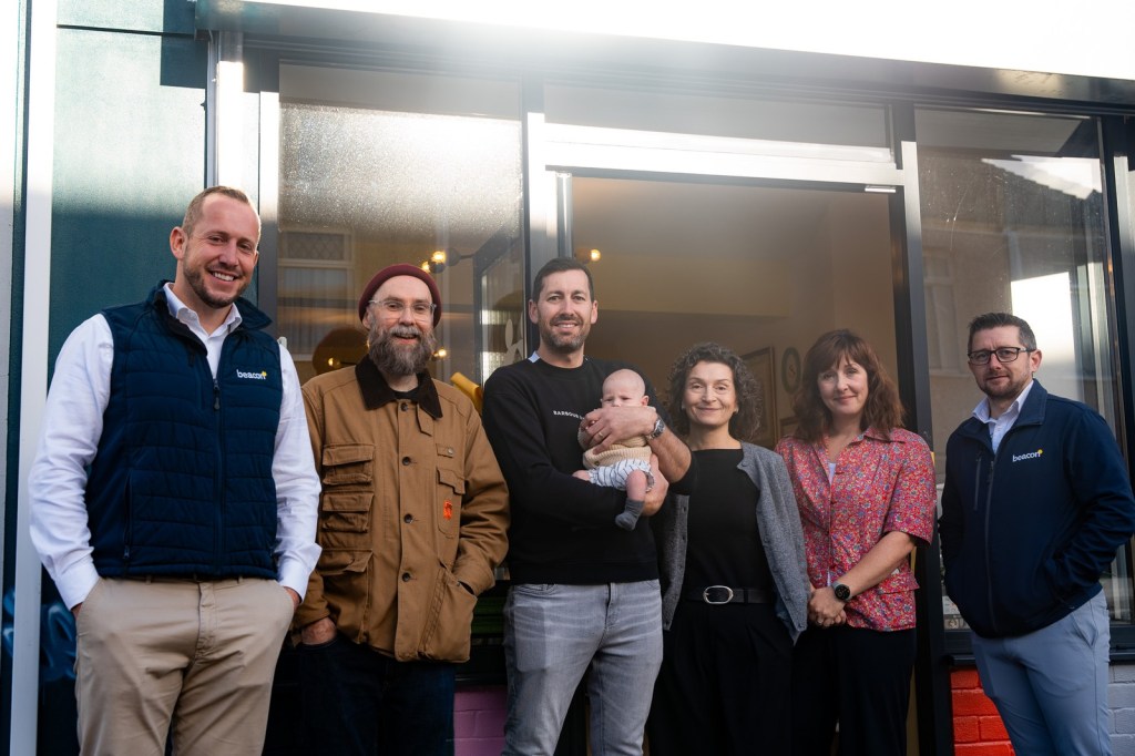 Six supporters, one holding a baby, stand outside the door of Y Stryd in Llanelli