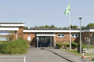 The entrance to Ysgol Heol Goffa special school in Llanelli, a single-storey brick building with a green flag flying outside