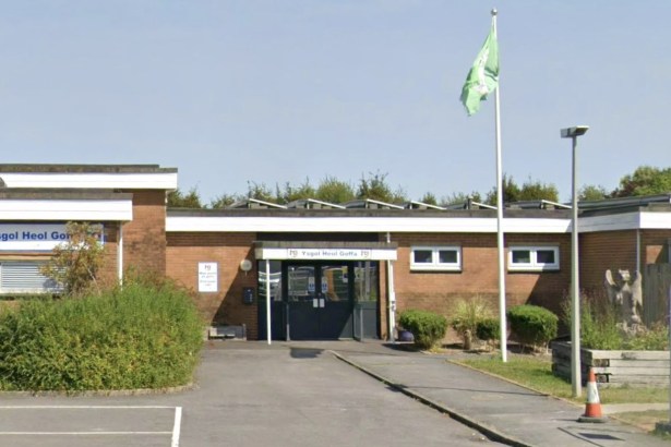 The entrance to Ysgol Heol Goffa special school in Llanelli, a single-storey brick building with a green flag flying outside