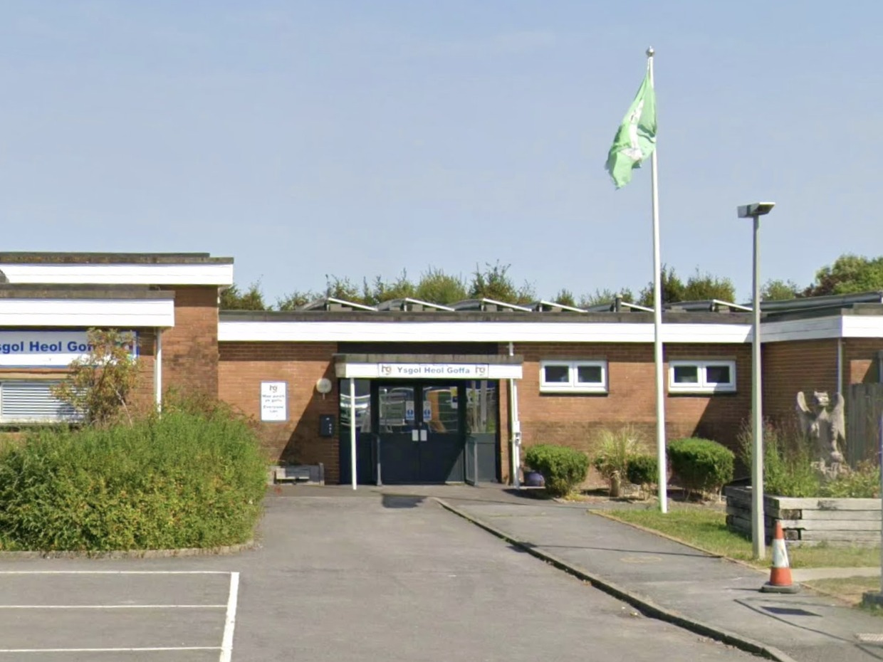 The entrance to Ysgol Heol Goffa special school in Llanelli, a single-storey brick building with a green flag flying outside