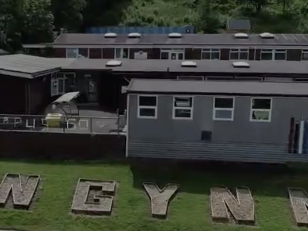 Aerial view of Ysgol Llangynnwr primary school in Llangunnor, Carmarthen, with the school name spelled out in large letters on the grass bank