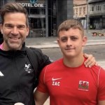 Gethin Jones with his arm around Zac Thomas, who wears a red Wales top with ZAC on the chest, in Swansea city centre