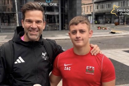 Gethin Jones with his arm around Zac Thomas, who wears a red Wales top with ZAC on the chest, in Swansea city centre